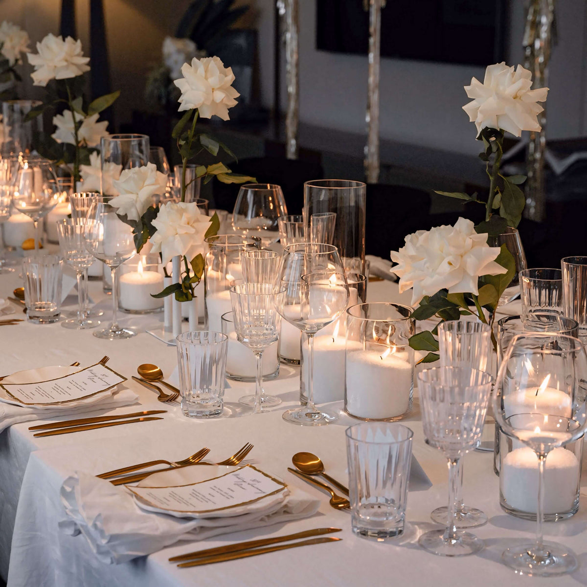 white sand candles and white single stem roses on king table